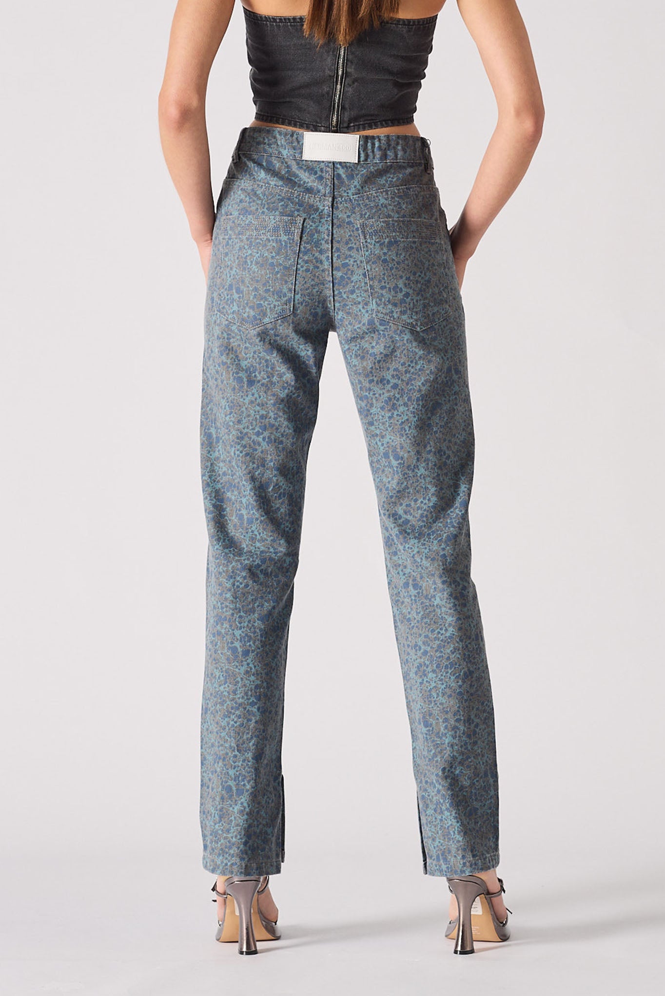 Person wearing blue patterned pants on a plain background
