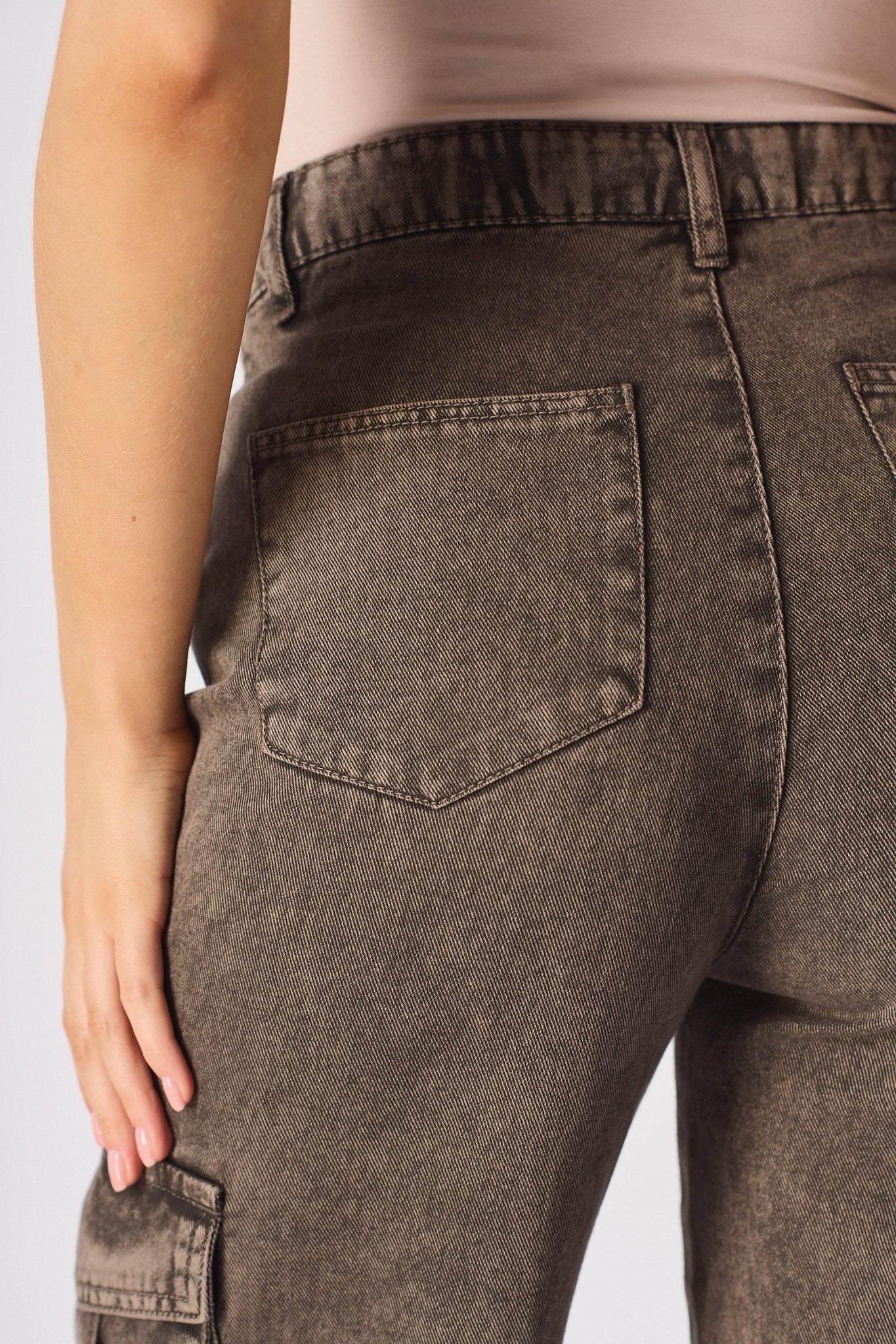 Zoomed in shot of the rear pockets and texture of the chocolate brown cargo jeans for women.