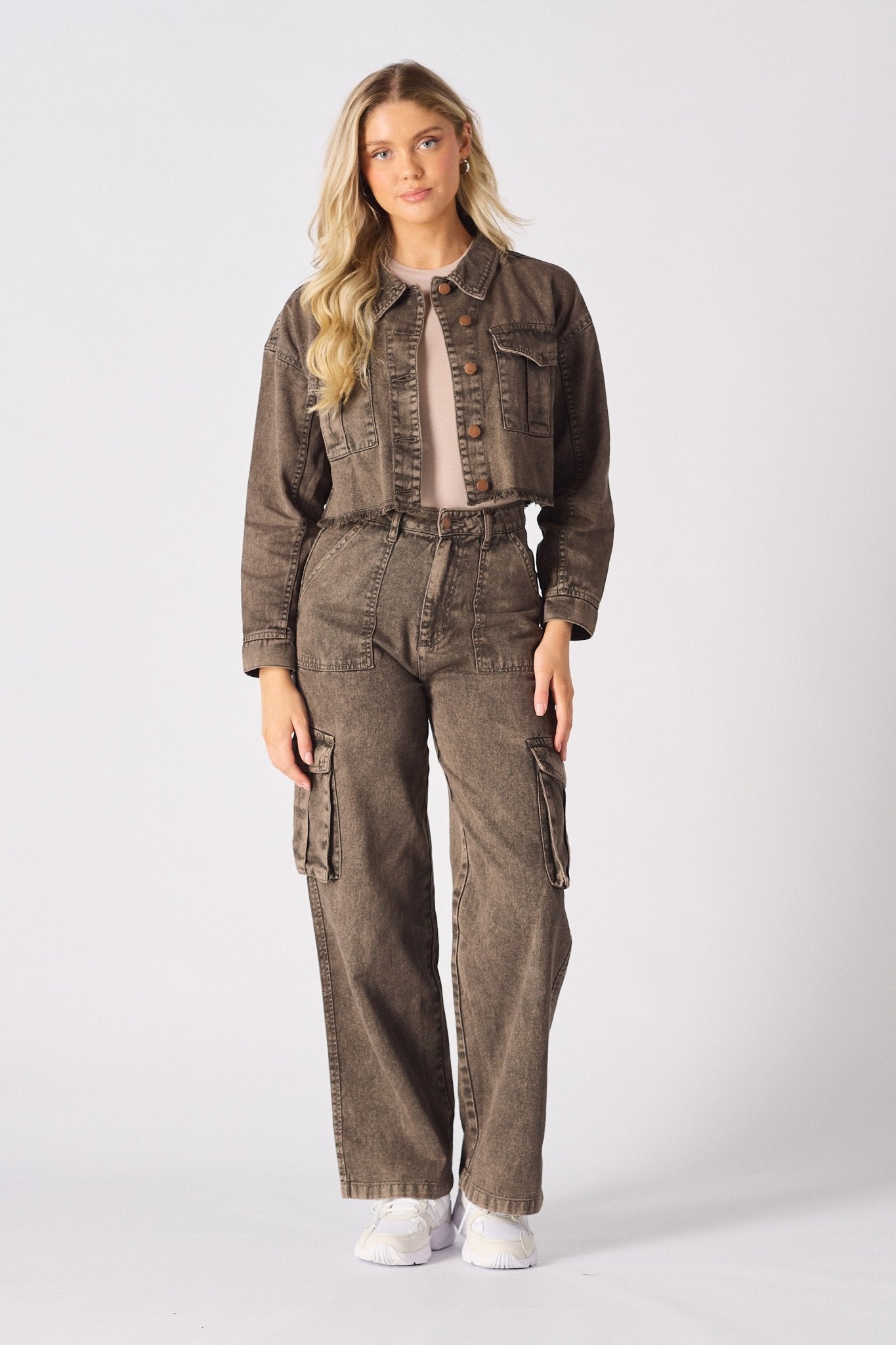 A woman wearing high-waisted wide leg brown cargo jeans for women with a matching denim jacket.