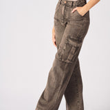 An angled shot of the model wearing brown cargo jeans for women focusing on the functional side pockets.