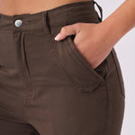 Close up shot of a hand in the front pocket of the brown cargo jeans showing fabric texture.