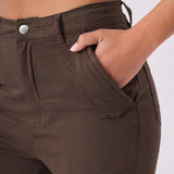 Close up shot of a hand in the front pocket of the brown cargo jeans showing fabric texture.