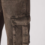 A detailed view of a cargo-style pocket on the durable brown denim fabric.