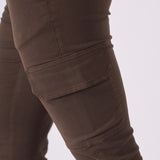 A zoomed in view of the functional side cargo pocket on the rich brown denim material.