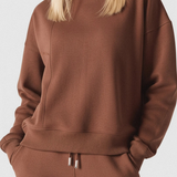 Close up shot of the fabric and neckline on a chocolate brown crew neck jumper