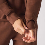 Detailed view of the ribbed cuffs on a brown crew neck jumper