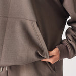 Detailed shot of the soft touch fabric and pocket on the brown quarter zip sweatshirt.