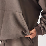 Detailed shot of the soft touch fabric and pocket on the brown quarter zip sweatshirt.