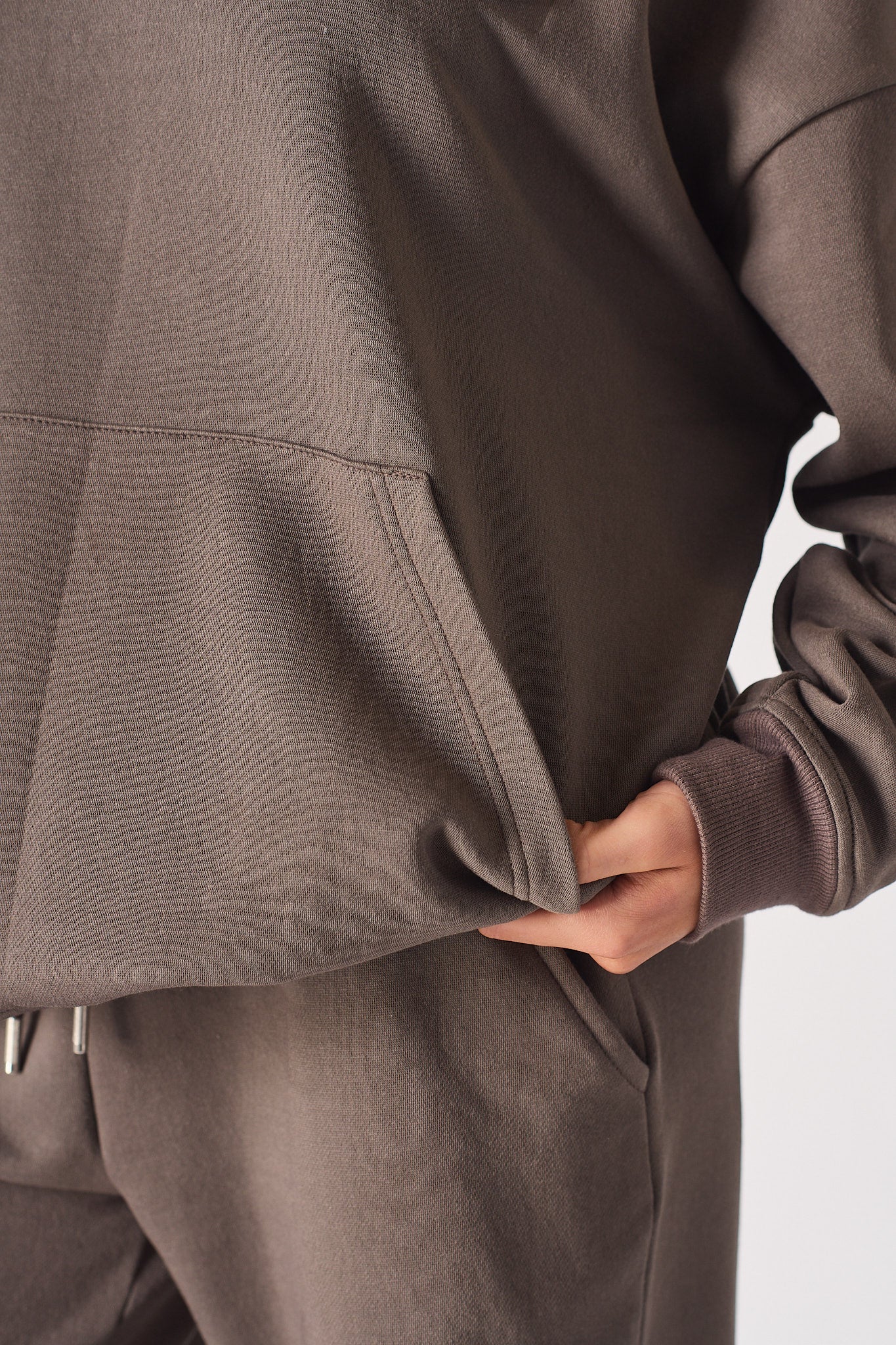 Detailed shot of the soft touch fabric and pocket on the brown quarter zip sweatshirt.