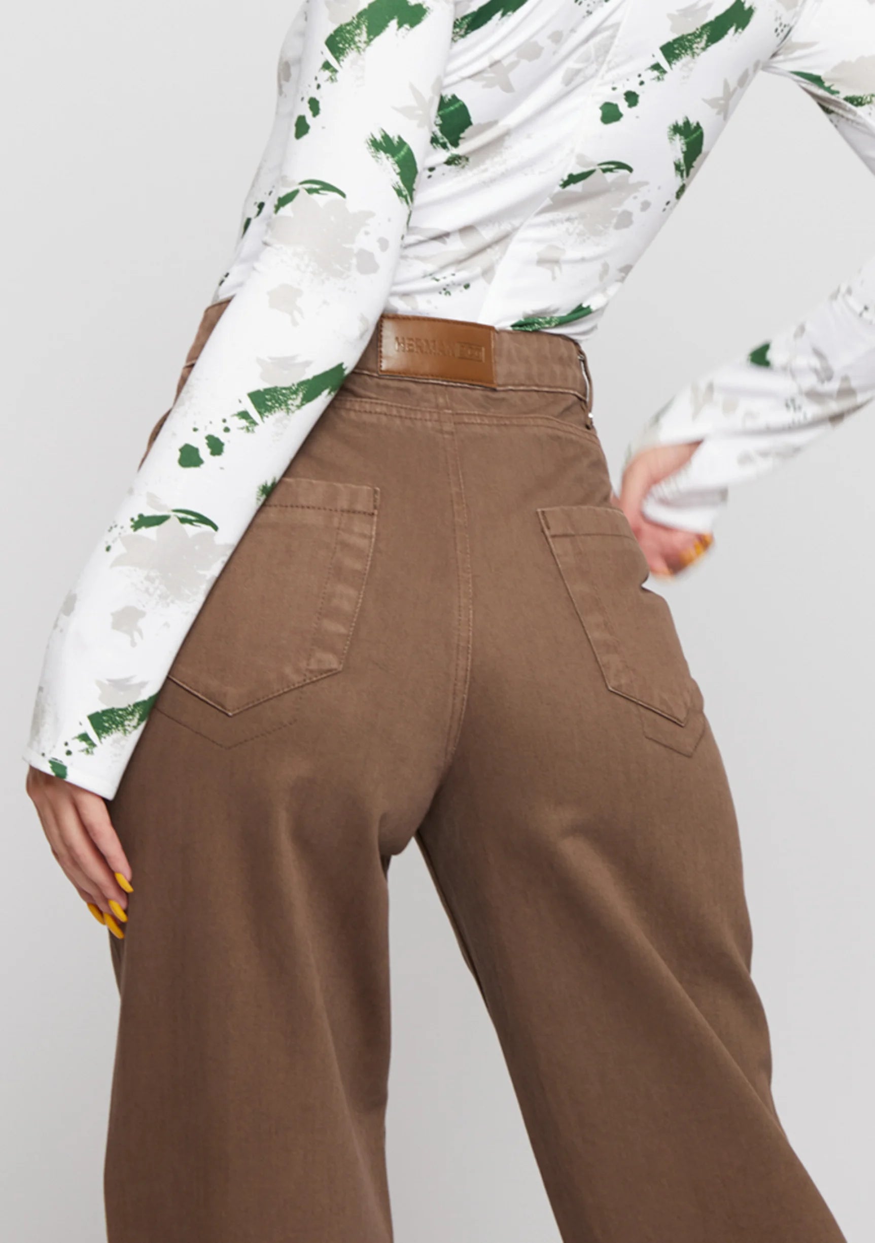 Close up of back pockets and leather brand patch on mocha brown wide leg pants