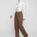 Side angle view of a model walking in mocha brown utility wide leg pants