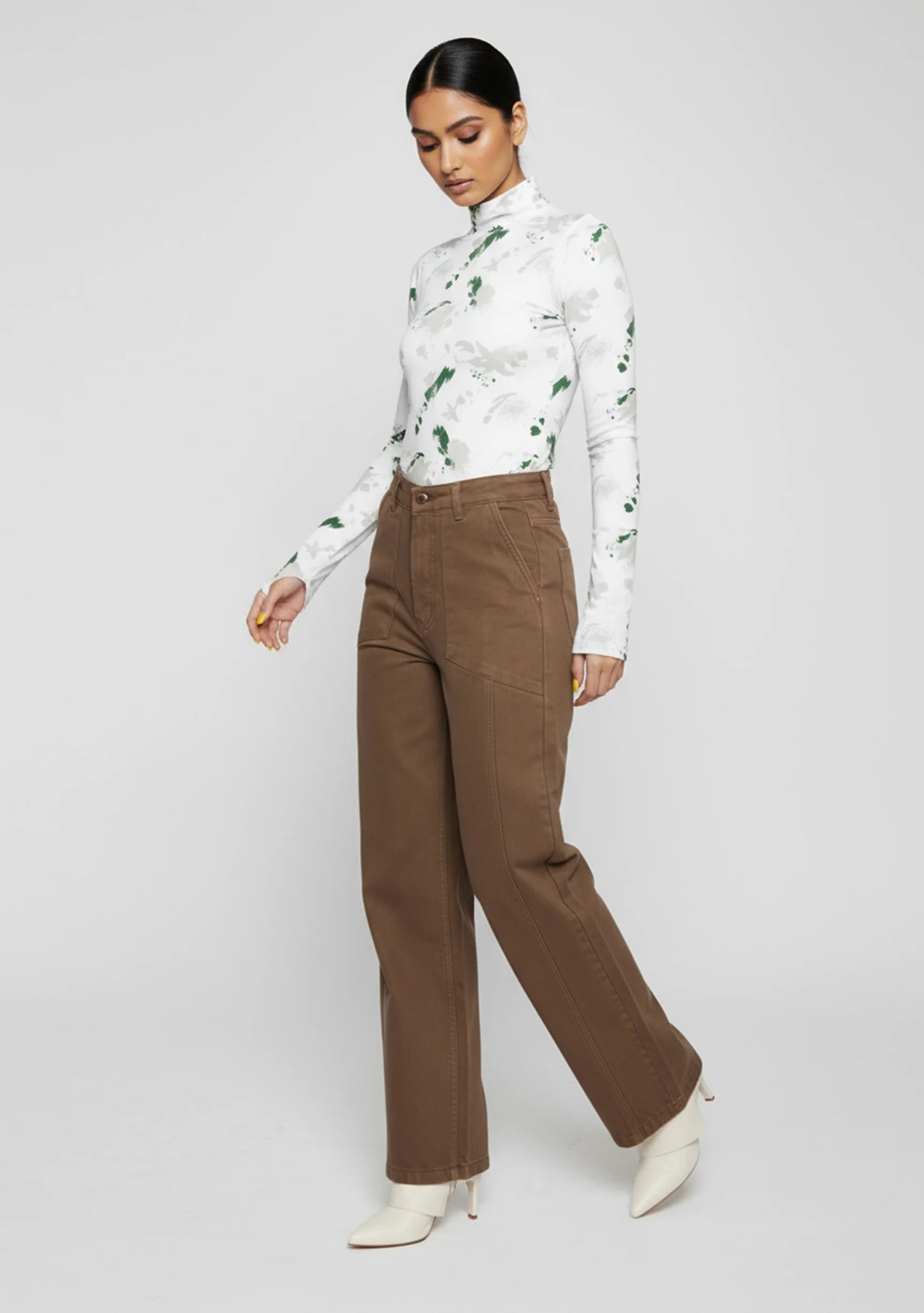 Side angle view of a model walking in mocha brown utility wide leg pants