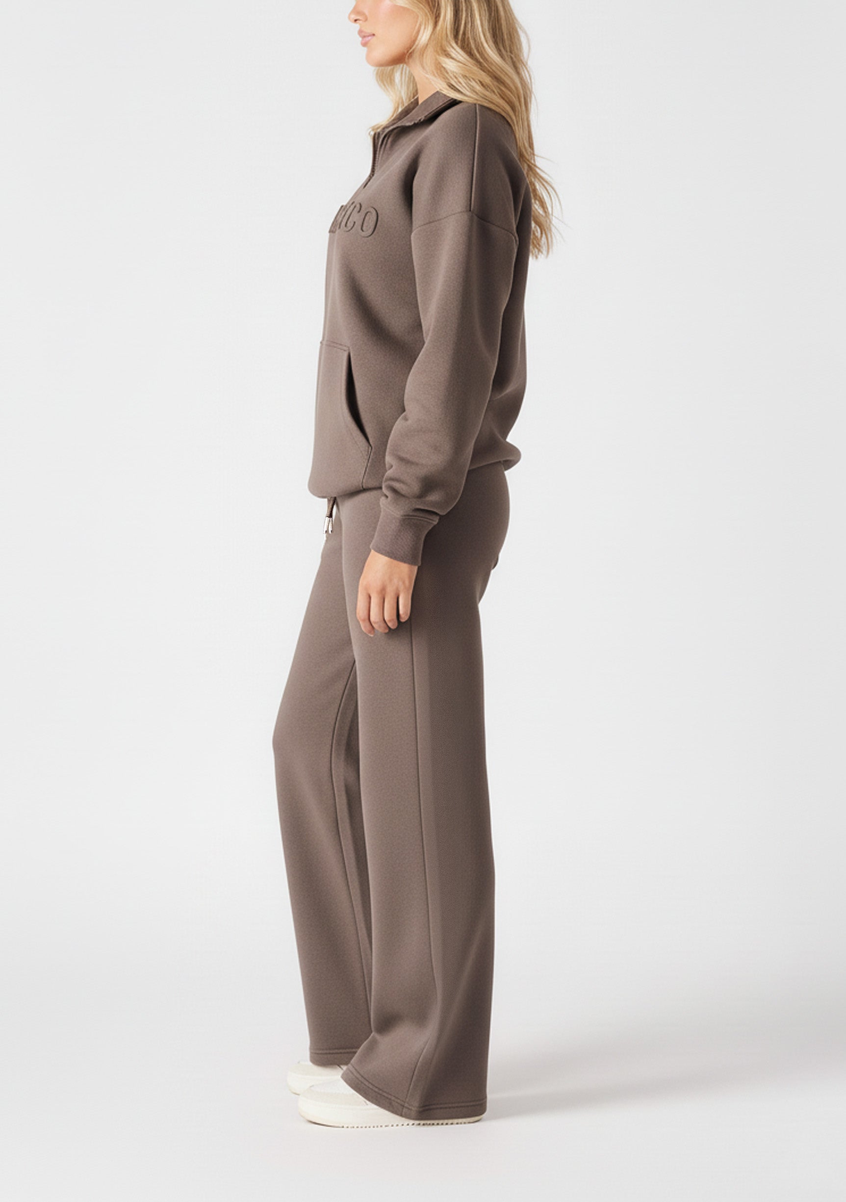 Side profile of a model wearing comfortable brown wide leg joggers women.
