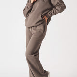 A model posing in premium brown wide leg joggers women with white trainers.