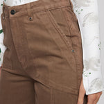 Close up of front patch pockets and stitching on high-waisted brown utility pants