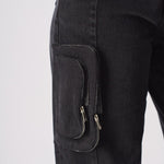 A close up of the side pocket on the black cargo jeans showing the zip attachment.