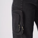 A close up of the side pocket on the black cargo jeans showing the zip attachment.