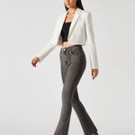 Side-front view of model walking in women's charcoal grey high-waisted bootcut jeans