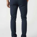 Full back view of a man standing straight in tailored chinos dark blue by Jmojo.