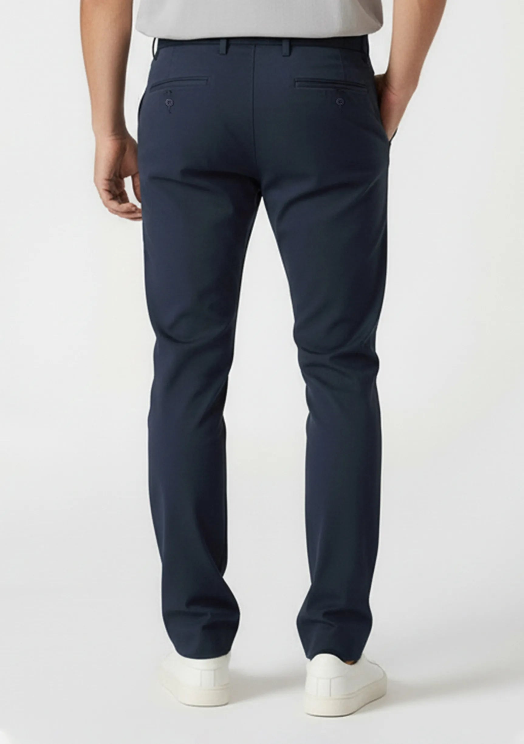 Full back view of a man standing straight in tailored chinos dark blue by Jmojo.