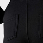 Close up back view of contrast panel high-waisted denim showing the black fabric and back pockets.