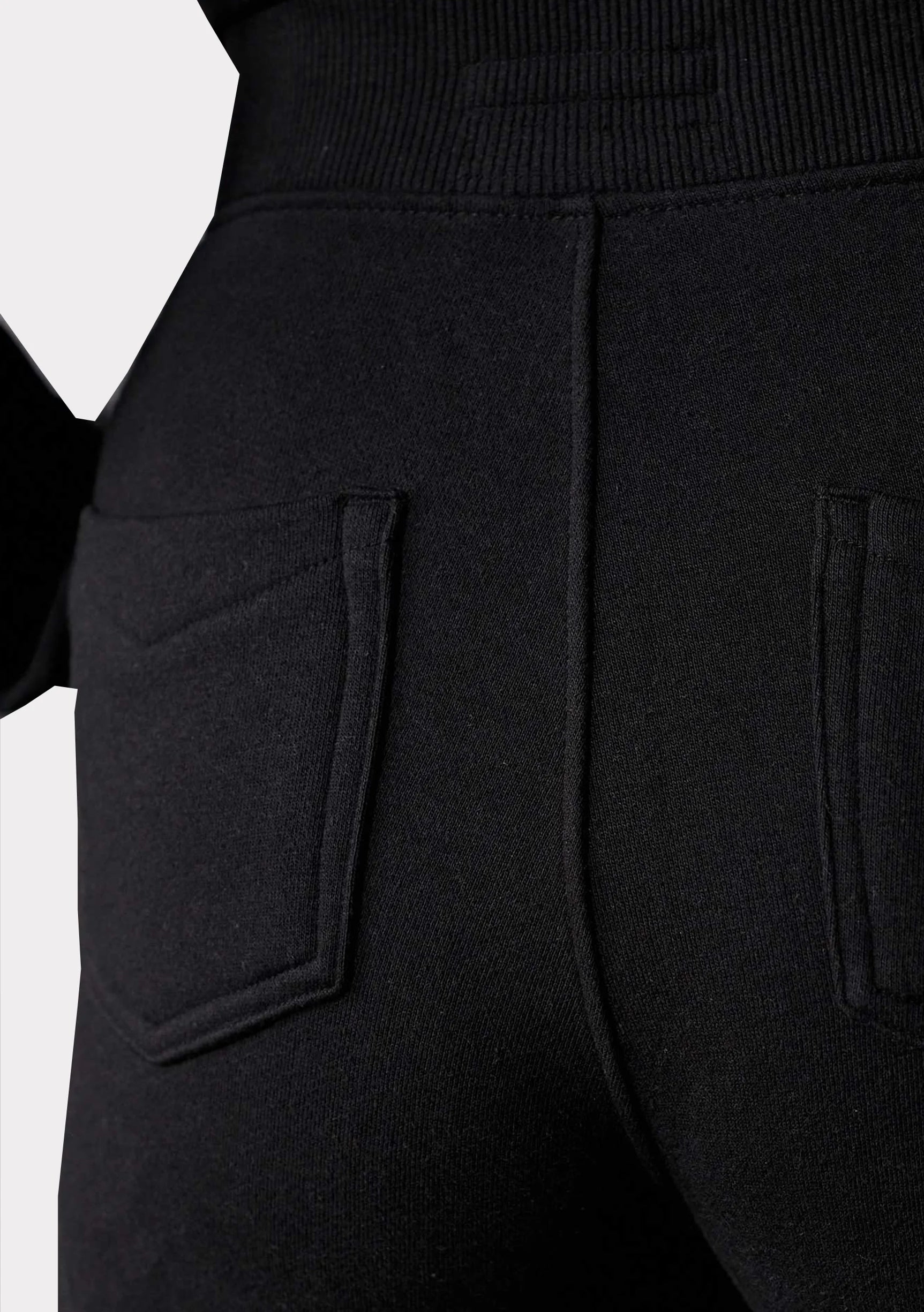Close up back view of contrast panel high-waisted denim showing the black fabric and back pockets.