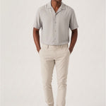 Full back view of a model wearing stretch slim fit cream trousers mens.