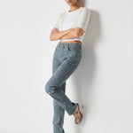 Model leaning on a wall in Dark Blue and Grey Speckled Women's Denim