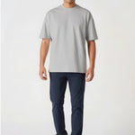 Handsome model walking forward wearing casual dark blue chinos for men.