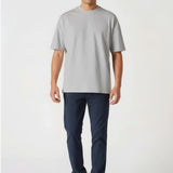 Handsome model walking forward wearing casual dark blue chinos for men.