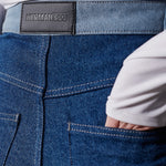 Close up of the back pockets and leather brand patch on two-tone denim jeans