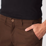 Detailed shot of the front pocket on dark brown slim fit chinos.