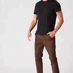 Side angle of a model wearing dark brown slim fit chinos.