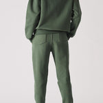 Rear view of an oversized dark green hoodie for women showing the hood and fit
