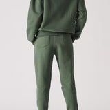 Rear view of an oversized dark green hoodie for women showing the hood and fit