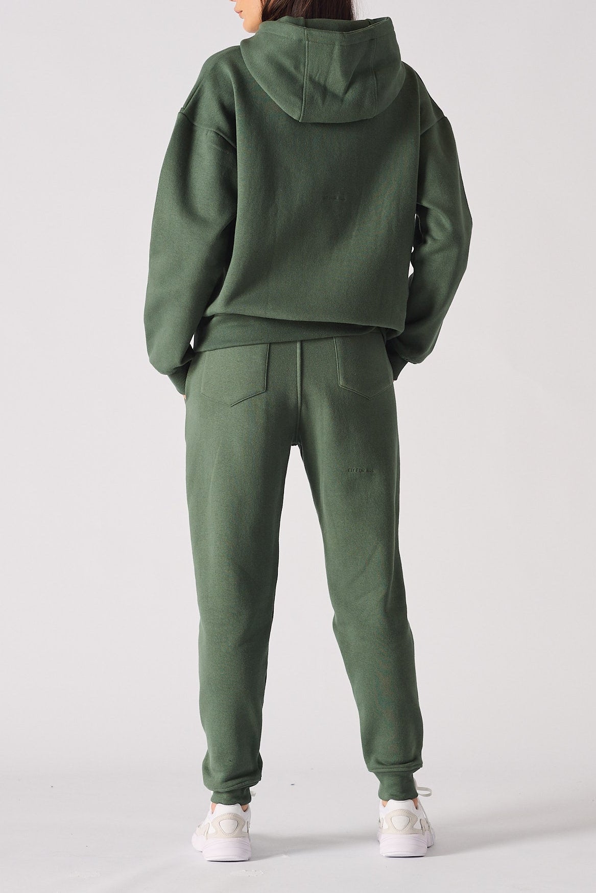 Rear view of an oversized dark green hoodie for women showing the hood and fit