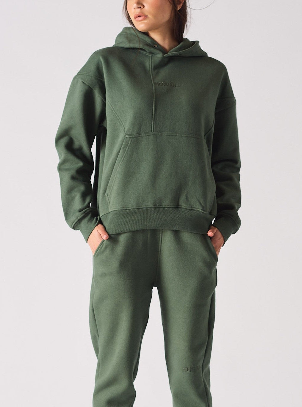 Front profile of a model styling a dark green hoodie with a matching lounge set