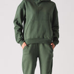 Front profile of a model styling a dark green hoodie with a matching lounge set
