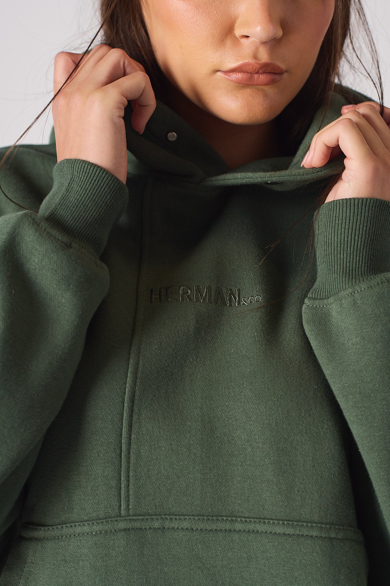 Close up of the unique popper neck detail on a dark green hoodie for women