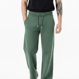 side angle view showing wide leg fit on dark green joggers