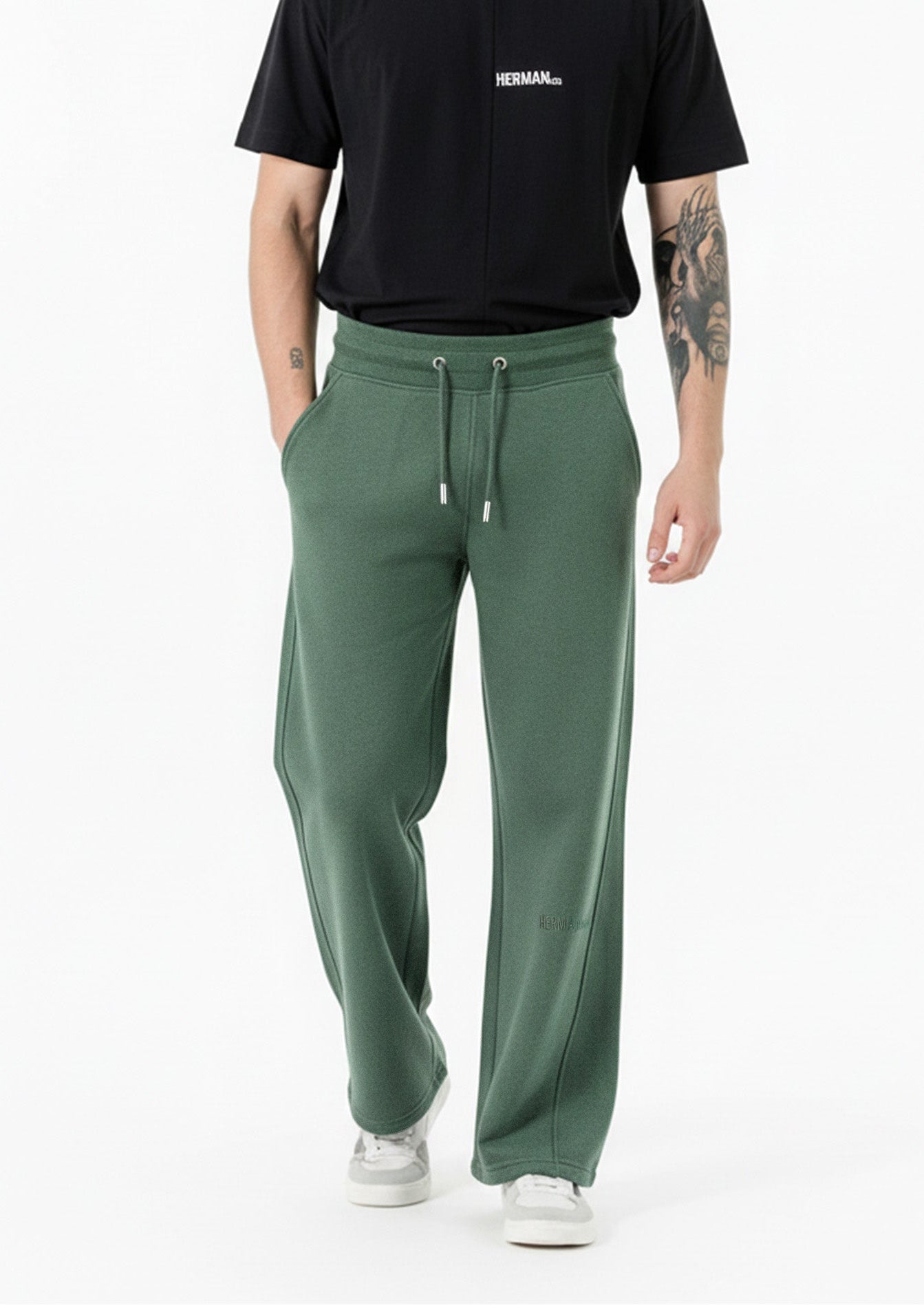 side angle view showing wide leg fit on dark green joggers