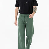man standing straight in dark green wide leg joggers