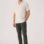 Full body view of a man wearing Jmojo dark olive chino slim fit stretch pants with a casual shirt.