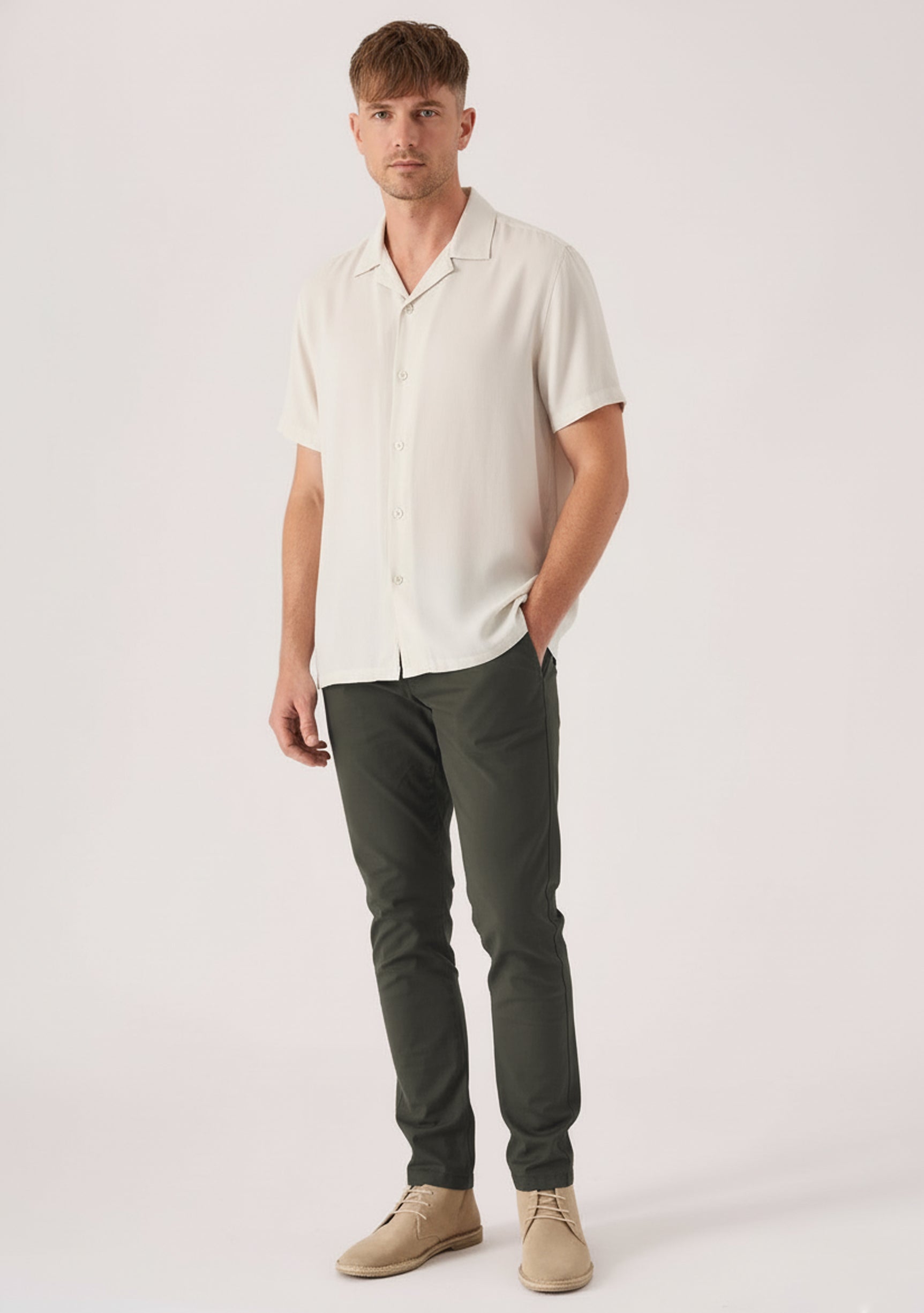 Full body view of a man wearing Jmojo dark olive chino slim fit stretch pants with a casual shirt.