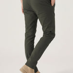 Detailed rear view highlighting the welt pockets and fit of the dark olive trousers.