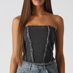 Close up of black distressed corset top showing frayed edge detailing and strapless design - women's textured denim bustier top