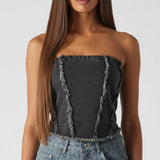 Close up of black distressed corset top showing frayed edge detailing and strapless design - women's textured denim bustier top