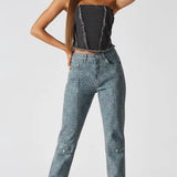 Front pose of black wash corset top with hand behind neck showing raw hem detail - women's textured denim bustier with cargo jeans