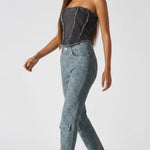 Side view of distressed textured corset top in black wash - women's strapless denim bustier with frayed edges styled with cargo jeans and heels