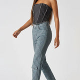 Side view of distressed textured corset top in black wash - women's strapless denim bustier with frayed edges styled with cargo jeans and heels